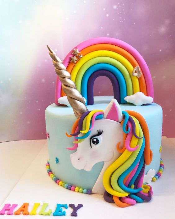 bolo com unicornio desenhado na cobertura e arco iris