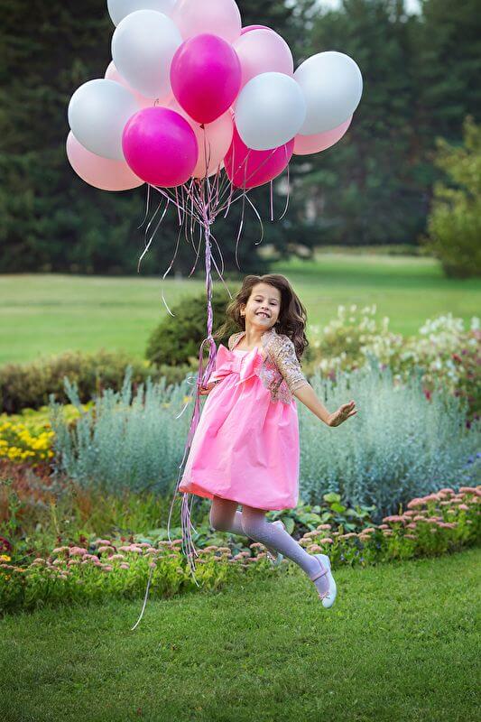 menina pulando com balões